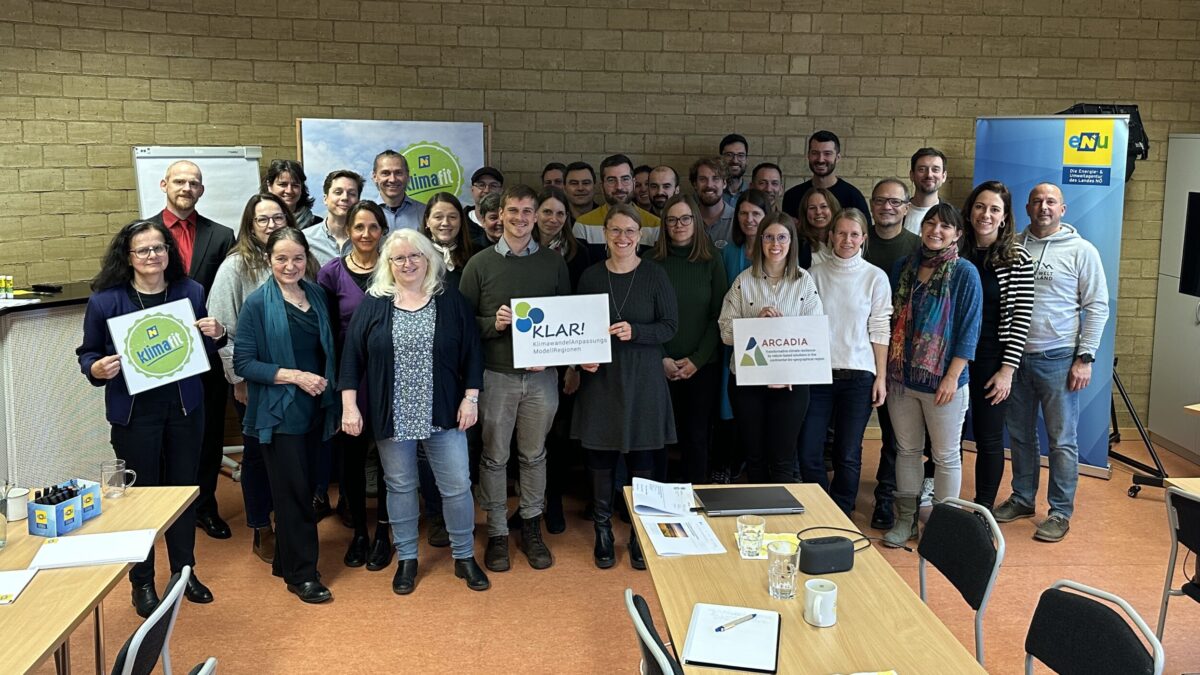 Gruppenfoto im Seminarraum der eNu, Roll ups im HIntergrund, tische und sessel im vordergrun, managerinnen und manager der KLAR! Regionen von Niederösterreich